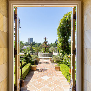 This is an example of a huge french country full sun backyard landscaping in Orange County.