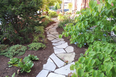 Photo of a traditional partial sun front yard stone landscaping in Toronto.