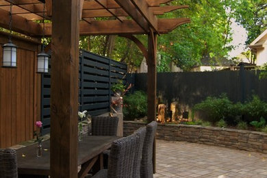 Imagen de jardín de estilo americano de tamaño medio en patio trasero con fuente, exposición parcial al sol y adoquines de hormigón