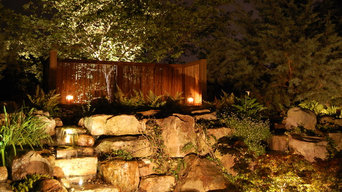 A backyard with landscape lighting for pond area