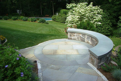 Cette image montre un grand jardin arrière traditionnel avec une exposition partiellement ombragée et des pavés en pierre naturelle.