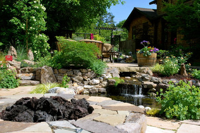 This is an example of a mid-sized traditional full sun backyard stone water fountain landscape in San Francisco for spring.