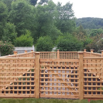 A custom lattice fence encloses a raised stone bed vegetable garden