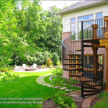 A Dramatic Spiral Stair Connects Deck & Back Yard. Minnesota Landscape Design.