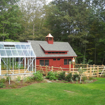A greenhouse, barn and vegetable garden