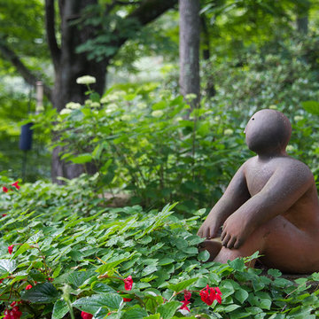 A Joy Brown Sculpture sitting in Epimedium