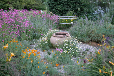 Ejemplo de jardín clásico de tamaño medio en primavera en patio trasero con exposición total al sol y gravilla