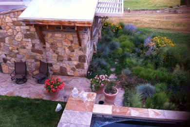 Diseño de jardín contemporáneo extra grande en verano en patio trasero con fuente, exposición total al sol y adoquines de piedra natural