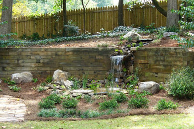 Inspiration for a partial sun backyard waterfall in Atlanta.
