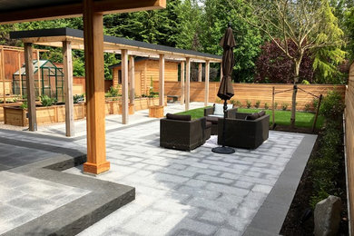 Inspiration for a large modern backyard stone patio remodel in Vancouver