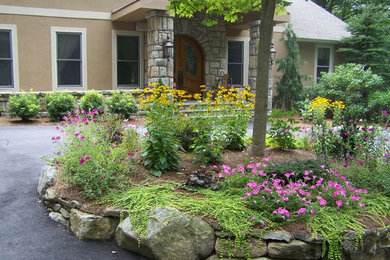 Пример оригинального дизайна: большой солнечный, летний участок и сад на переднем дворе в классическом стиле с хорошей освещенностью, покрытием из каменной брусчатки, подъездной дорогой и подпорной стенкой