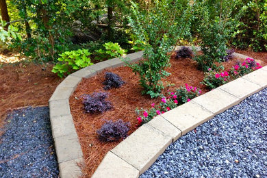 Photo of a mid-sized traditional partial sun backyard gravel retaining wall landscape in Atlanta.