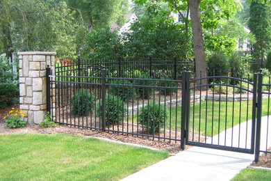Photo of a large transitional backyard metal fence landscaping in Minneapolis.