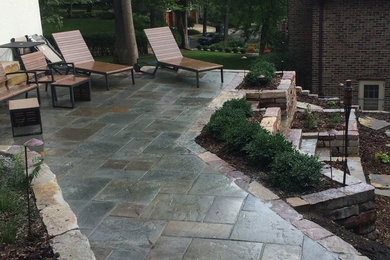 This is an example of a large traditional partial sun backyard stone landscaping in Minneapolis for summer.