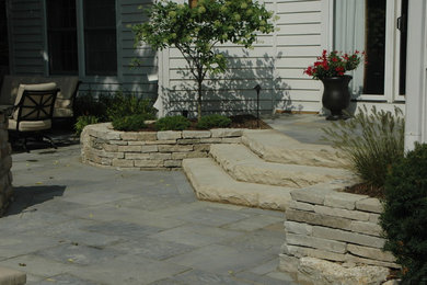 Photo of a large eclectic partial sun backyard stone landscaping in Columbus.