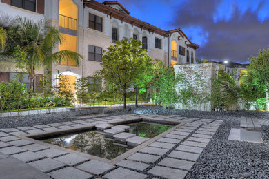Inspiration for a contemporary garden in Miami with a water feature and gravel.