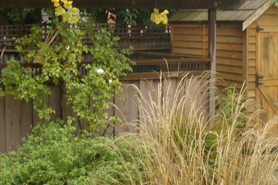 Diseño de camino de jardín clásico de tamaño medio en primavera en patio trasero con jardín francés, exposición parcial al sol y adoquines de piedra natural