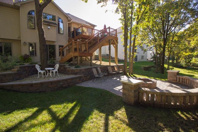 Design ideas for a mid-sized traditional shade backyard concrete paver landscaping in Minneapolis with a fire pit.