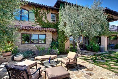 Diseño de jardín mediterráneo en verano en patio trasero con exposición total al sol y adoquines de piedra natural