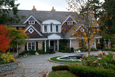 Design ideas for a huge traditional partial sun front yard stone driveway in Vancouver for fall.