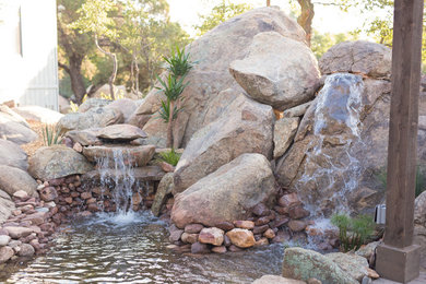 This is an example of a large southwestern partial sun backyard stone pond in Phoenix.