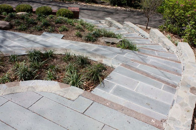 Diseño de jardín tradicional de tamaño medio en primavera en patio delantero con muro de contención, exposición reducida al sol y adoquines de piedra natural