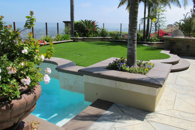 Design ideas for a mid-sized tropical drought-tolerant and full sun backyard concrete paver landscaping in Los Angeles.