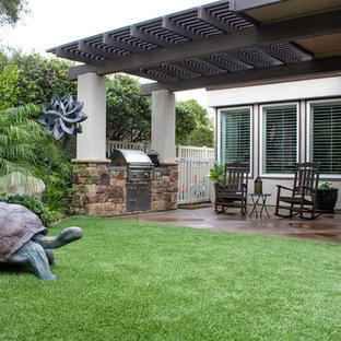 Großer Landhaus Garten hinter dem Haus mit Kamin, direkter Sonneneinstrahlung und Betonplatten in Orange County