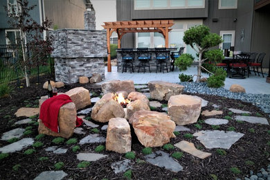 Inspiration for a mid-sized traditional partial sun backyard stone formal garden in Kansas City with a fire pit.
