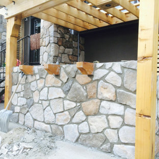 Großer Garten neben dem Haus mit Kamin und Natursteinplatten in Calgary