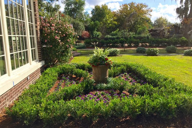 Идея дизайна: регулярный сад на заднем дворе в классическом стиле с растениями в контейнерах и покрытием из каменной брусчатки