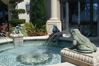 This is an example of a mid-sized mediterranean courtyard water fountain landscape in Orange County.