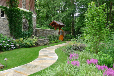 Expansive traditional side fully shaded garden for summer in New York with a garden path and natural stone paving.
