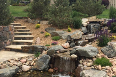 Inspiration for a large rustic full sun backyard stone pond in Denver.