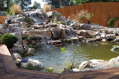 This is an example of a mid-sized tropical full sun backyard landscaping in Los Angeles for spring.