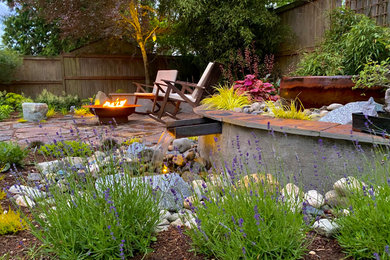 Inspiration for a mid-sized rustic backyard stone landscaping in Seattle.