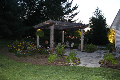This is an example of a mid-sized traditional full sun backyard landscaping in Other.