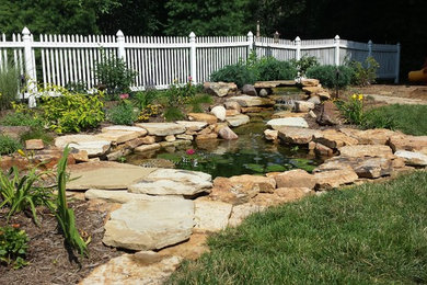 Diseño de jardín clásico grande en patio trasero con estanque, exposición total al sol y adoquines de piedra natural