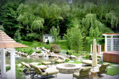 Modelo de jardín clásico de tamaño medio en primavera en patio trasero con jardín francés, fuente, exposición total al sol y adoquines de piedra natural