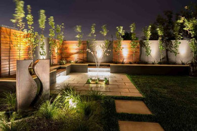 Immagine di un grande giardino formale moderno esposto in pieno sole dietro casa con pavimentazioni in cemento e un ingresso o sentiero