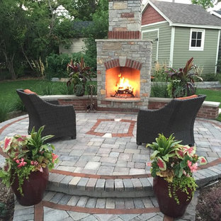 Mittelgroßer Uriger Garten im Sommer, hinter dem Haus mit Kamin und Betonplatten in Minneapolis