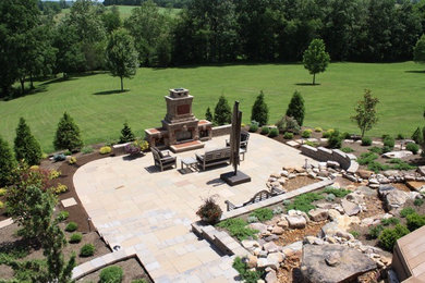 Photo of an expansive back full sun garden in Other with a fire feature and natural stone paving.