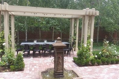 This is an example of a medium sized traditional formal garden in Other with brick paving.