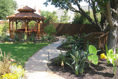 This is an example of a large traditional partial sun backyard landscaping in Dallas.