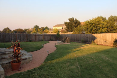 This is an example of a large transitional full sun backyard gravel landscaping in Austin.