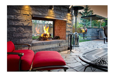 Design ideas for a large contemporary partial sun backyard stone formal garden in Edmonton with a fire pit.