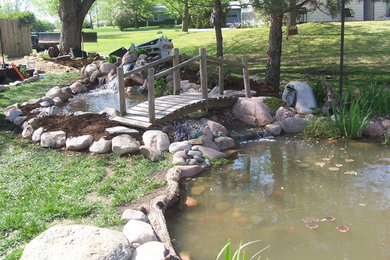 This is an example of a traditional partial sun backyard stone water fountain landscape in Kansas City for summer.