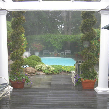Backyard pool are with pergola in the rain