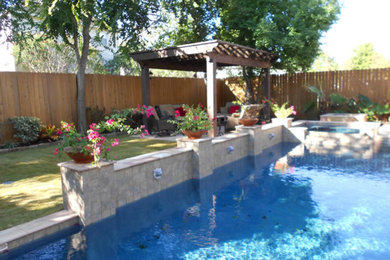 This is an example of a large traditional partial sun backyard stone water fountain landscape in Houston.