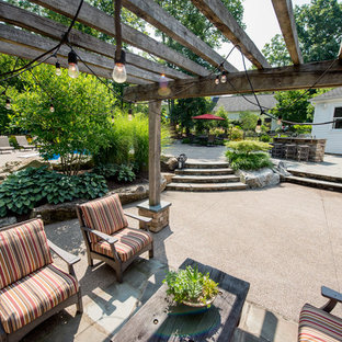 Großer, Halbschattiger Klassischer Garten im Sommer, hinter dem Haus mit Kamin und Natursteinplatten in Sonstige